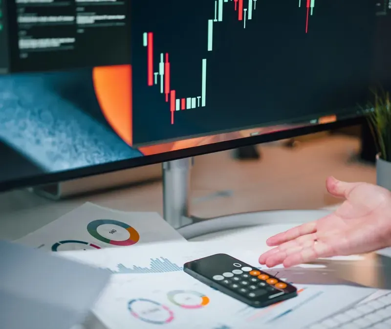Reports and charts open on a monitor at a desk
