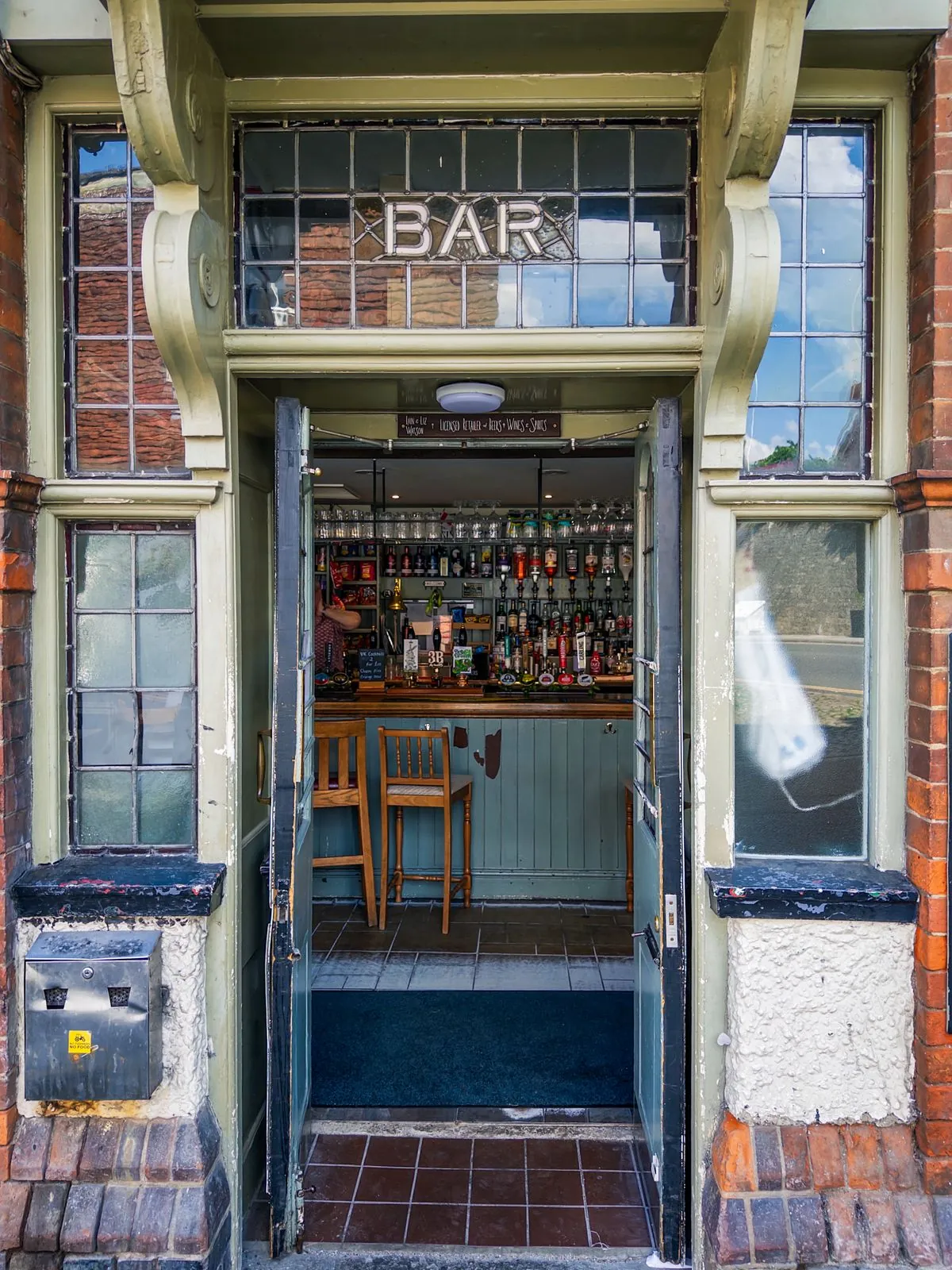 The tiled entrance and bar window of an English pub